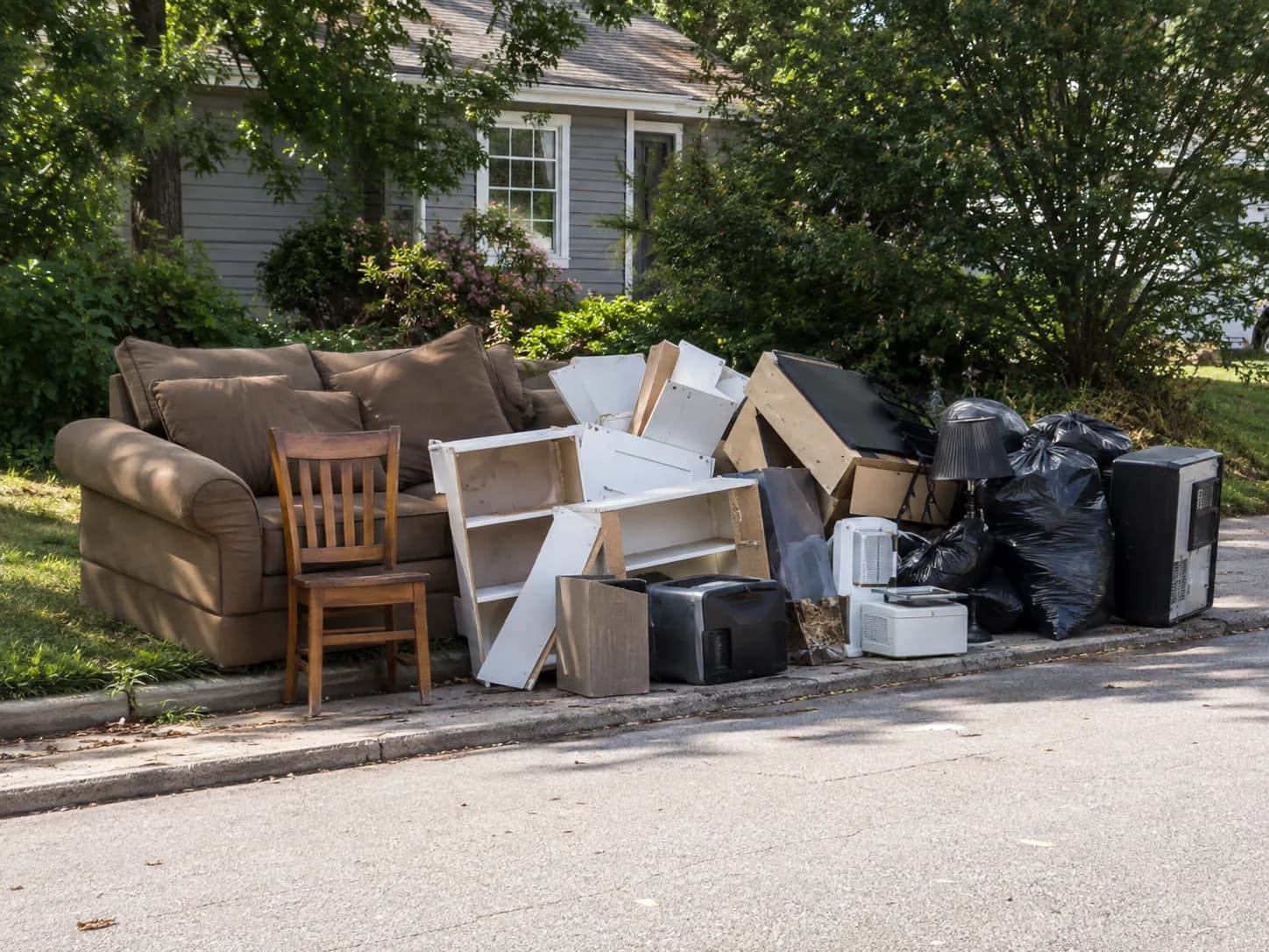 Couch, chair and shelving stacked at a Dallas curb for pickup