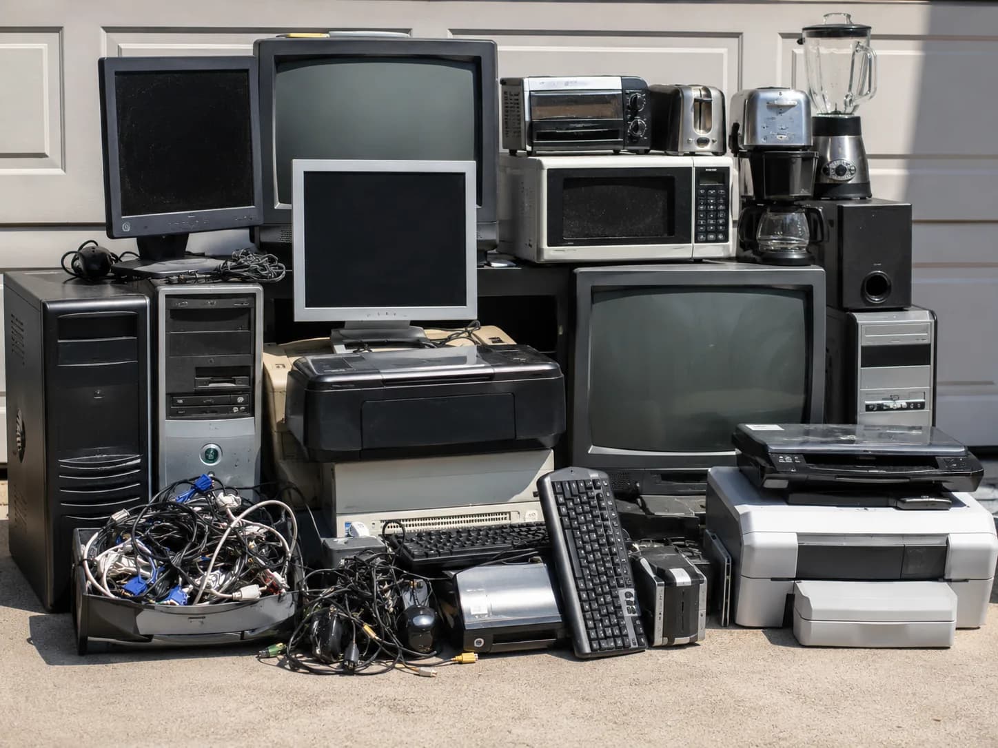 Pile of old televisions, monitors, computers and printers